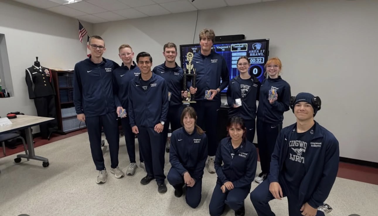 Kingwood NJROTC academic team in navy tracksuits holding a competition trophy