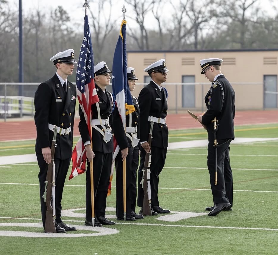 Kingwood NJROTC color guard in formation on the field with the American and Texas flags
