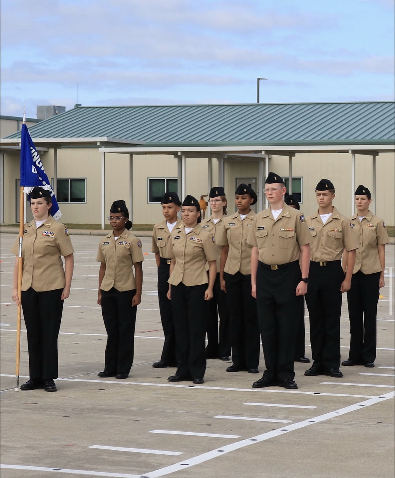 Kingwood NJROTC unarmed drill team standing in formation with the unit guidon